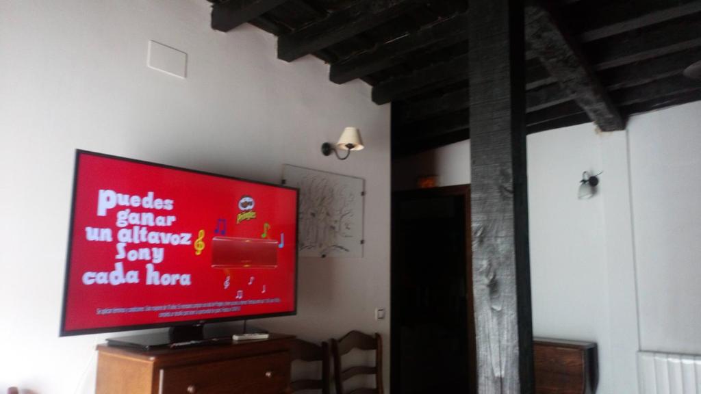 TV de pantalla plana en la parte superior de un armario de madera en Apartamentos Rurales Víctor Chamorro del Arco, en Hervás
