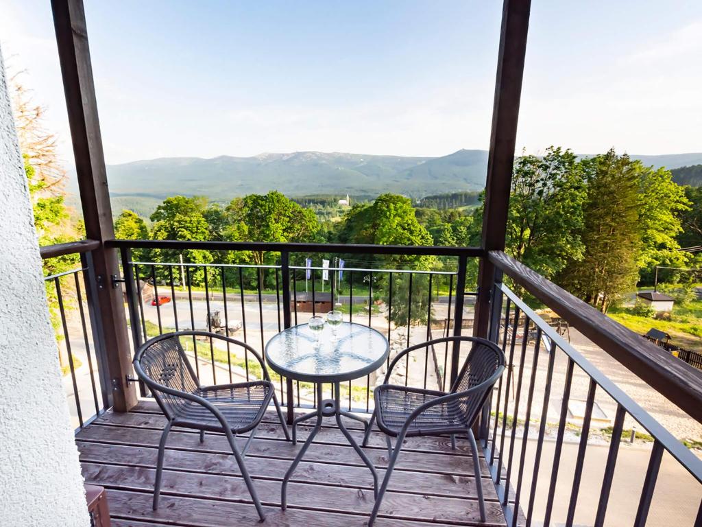 einen Tisch und Stühle auf einem Balkon mit Aussicht in der Unterkunft VacationClub – Górna Resorts Apartament 1.33 in Szklarska Poręba