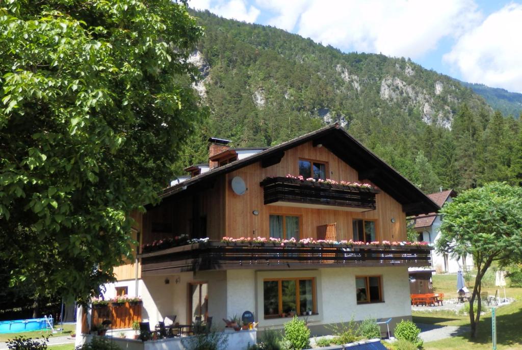 a house with flowers on the balcony in front of a mountain at Ferienhaus Bella Vista in Lake Pressegg