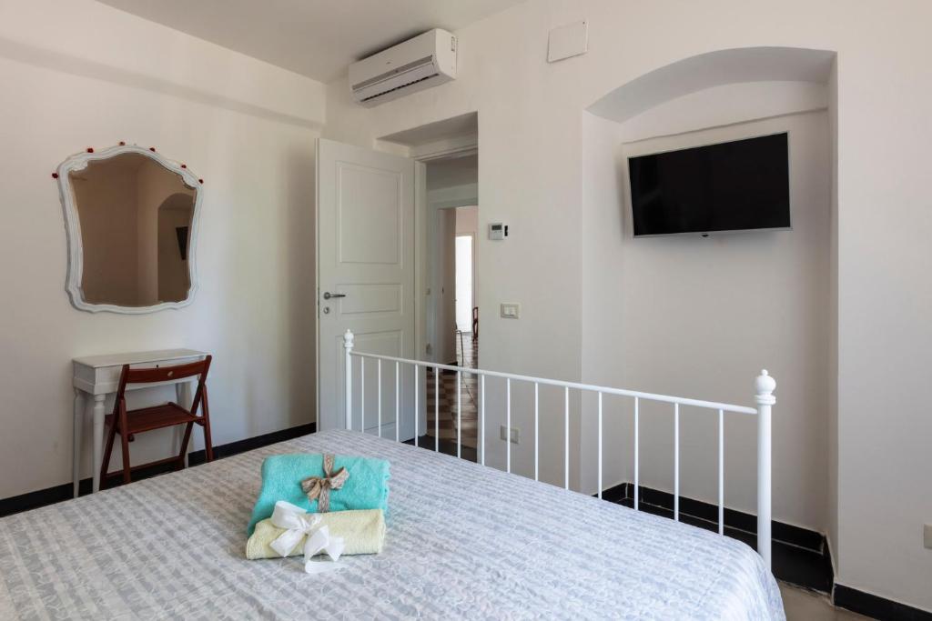 a bedroom with a bed with a pillow and a television at La BRIGNA B&B Il bosco sul mare in Genoa