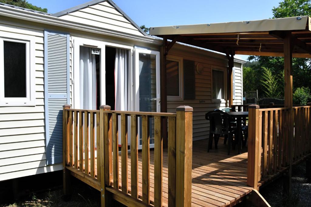 une terrasse couverte d&#39;une maison avec une terrasse en bois dans l&#39;établissement Camping du Bourg, à Digne-Les-Bains