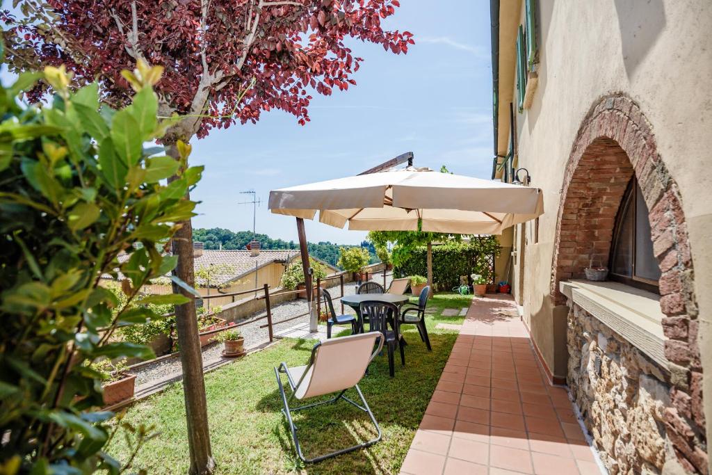un patio con mesa y sombrilla en Casetta Luna e Sole, en Montescudaio