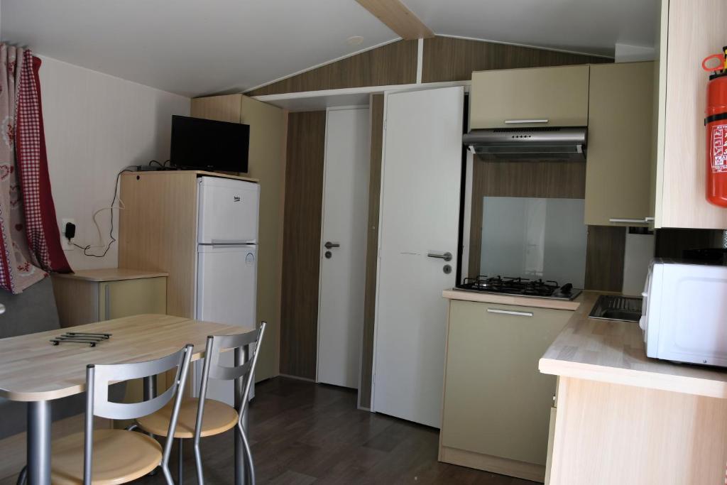 - une cuisine avec une table et des chaises dans la chambre dans l&#39;établissement Camping du Bourg, à Digne-Les-Bains