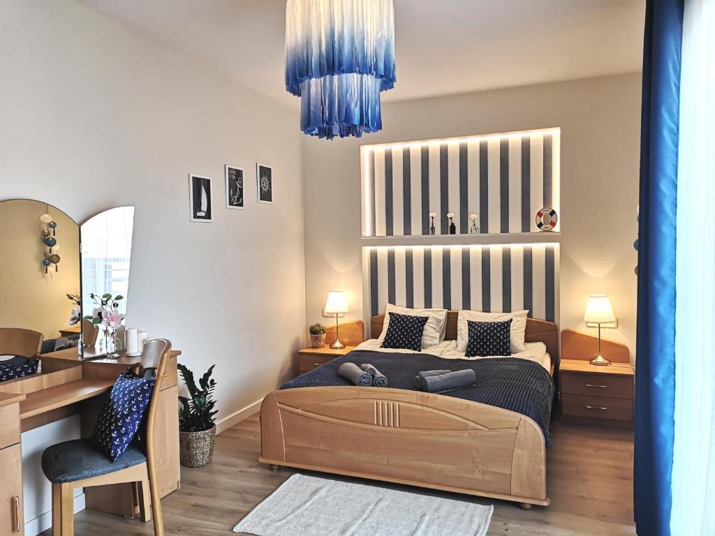 Schlafzimmer mit einem Bett, einem Schreibtisch und einem Stuhl in der Unterkunft Marine Apartament in Danzig
