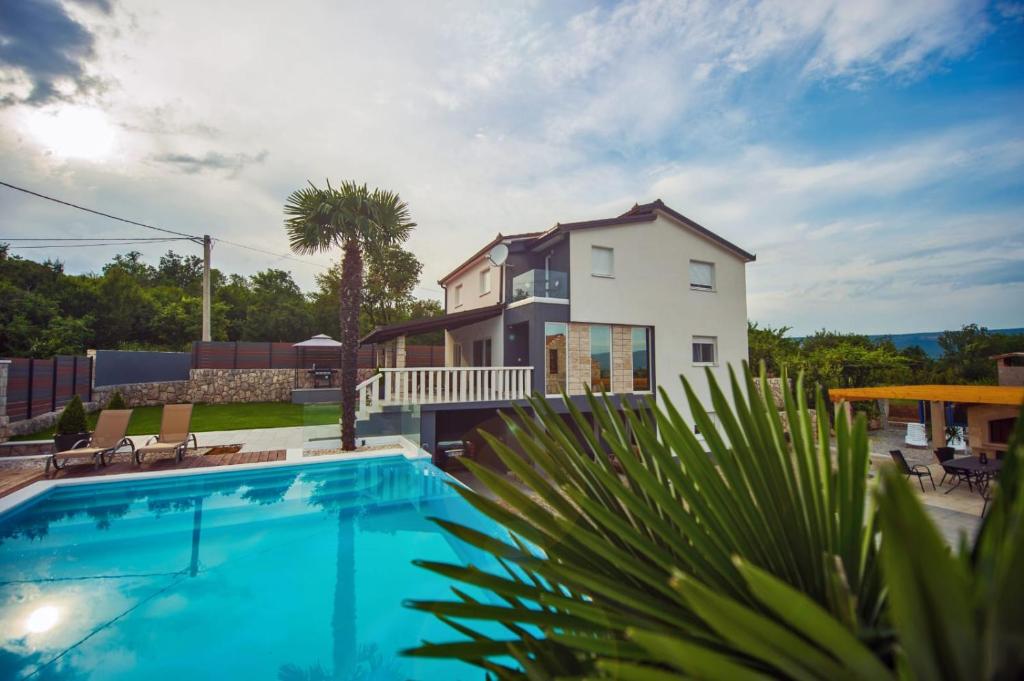 a house with a swimming pool in front of a house at Villa Vida in Zmijavci