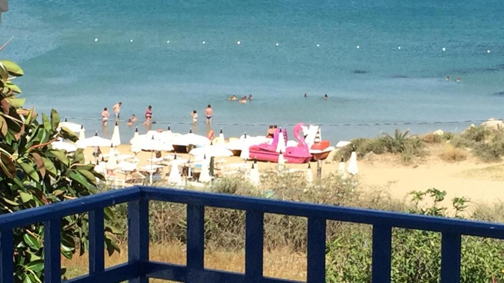 a beach with umbrellas and people in the water at oasi scala dei turchi in Realmonte