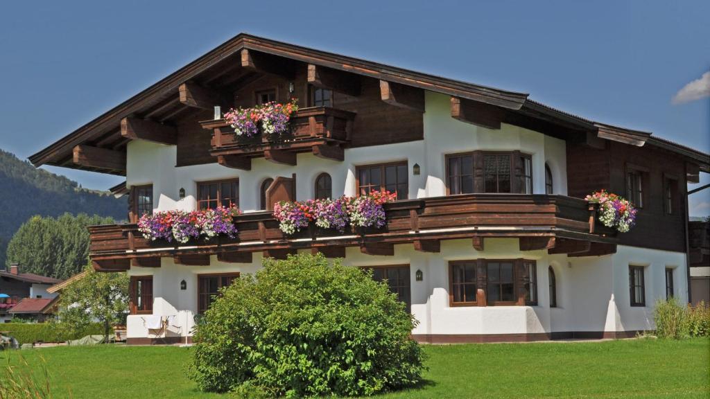 una casa grande con flores en el balcón en Appartement Mayr, en Kirchdorf in Tirol