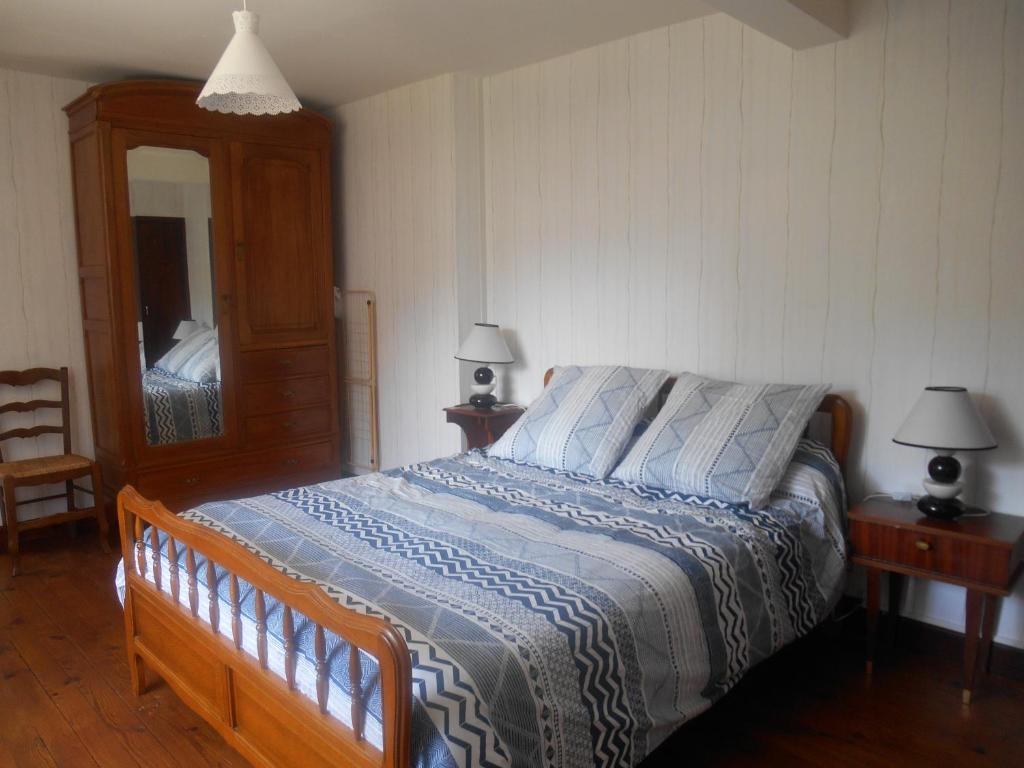 ein Schlafzimmer mit einem Bett, einem Spiegel und zwei Lampen in der Unterkunft Appartement Vallée de Luchon in Salles-et-Pratviel