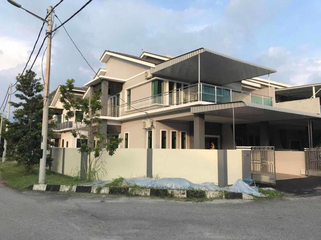 een groot wit gebouw met een veranda en een balkon bij Family Homestay in Taiping