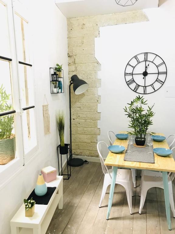 une salle à manger avec une table et une horloge au mur dans l'établissement Superbe! Loft T3 -Ctre Historic- Prox. Place Comédie, à Montpellier
