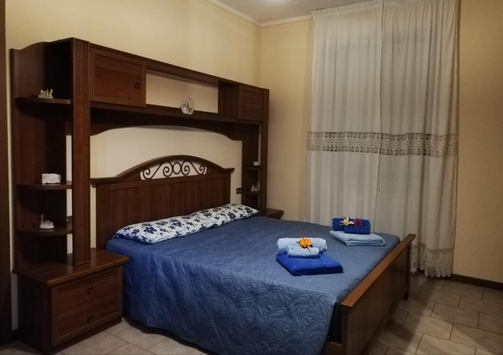 a bedroom with a bed with blue sheets and a canopy at Ginger's House MALPENSA in Cardano al Campo