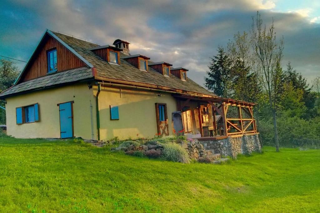 een oud huis op een heuvel met een groen veld bij Nebo nad Štiavnicou - čarovná chalupa so záhradou in Banská Štiavnica