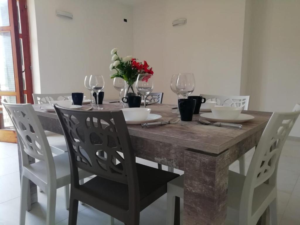 a dining room table with chairs and wine glasses at Cilento Relax City House in Montecorice