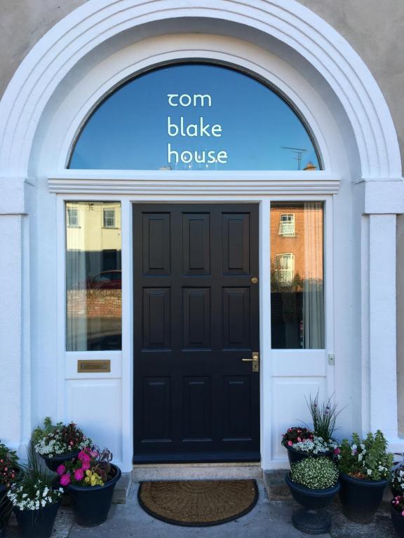 een ingang naar een maïsblake huis met een zwarte deur bij Tom Blake House in Kells