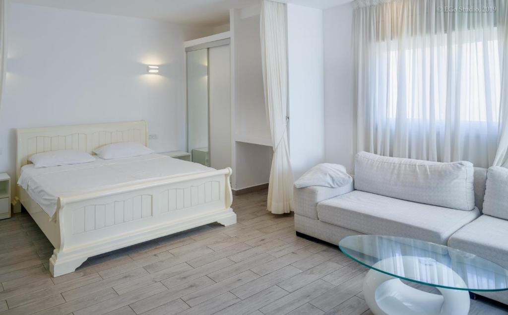 een slaapkamer met een bed, een bank en een tafel bij Royal Lea Apartmens in Netanya