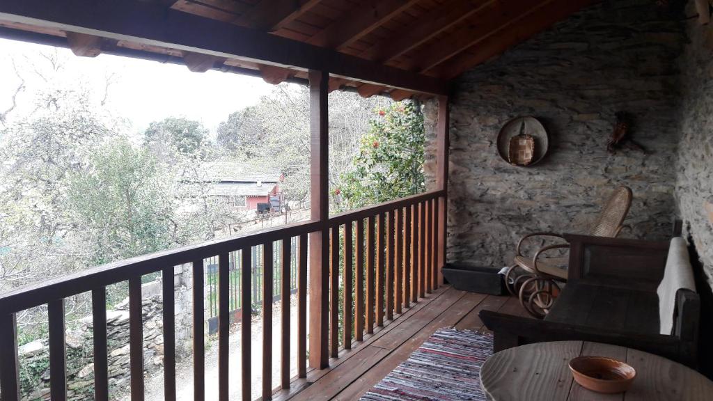 um alpendre com uma grande janela e um corrimão de madeira em Casa rural Albina em Susañe del Sil
