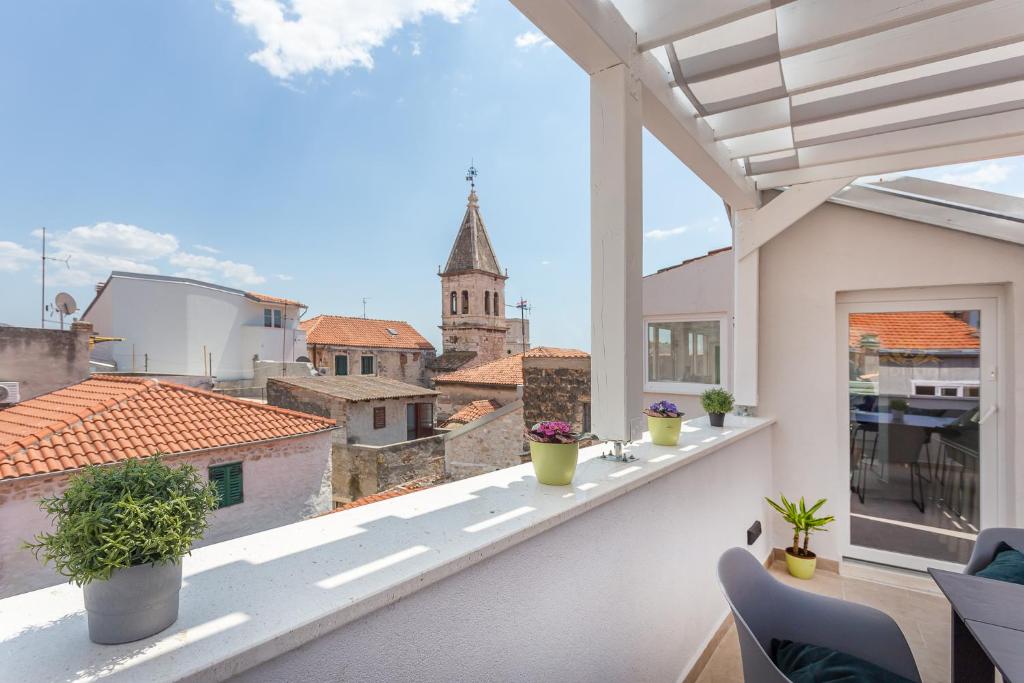 een balkon met planten en uitzicht op de stad bij Xboutique Rooms Marinac in Šibenik