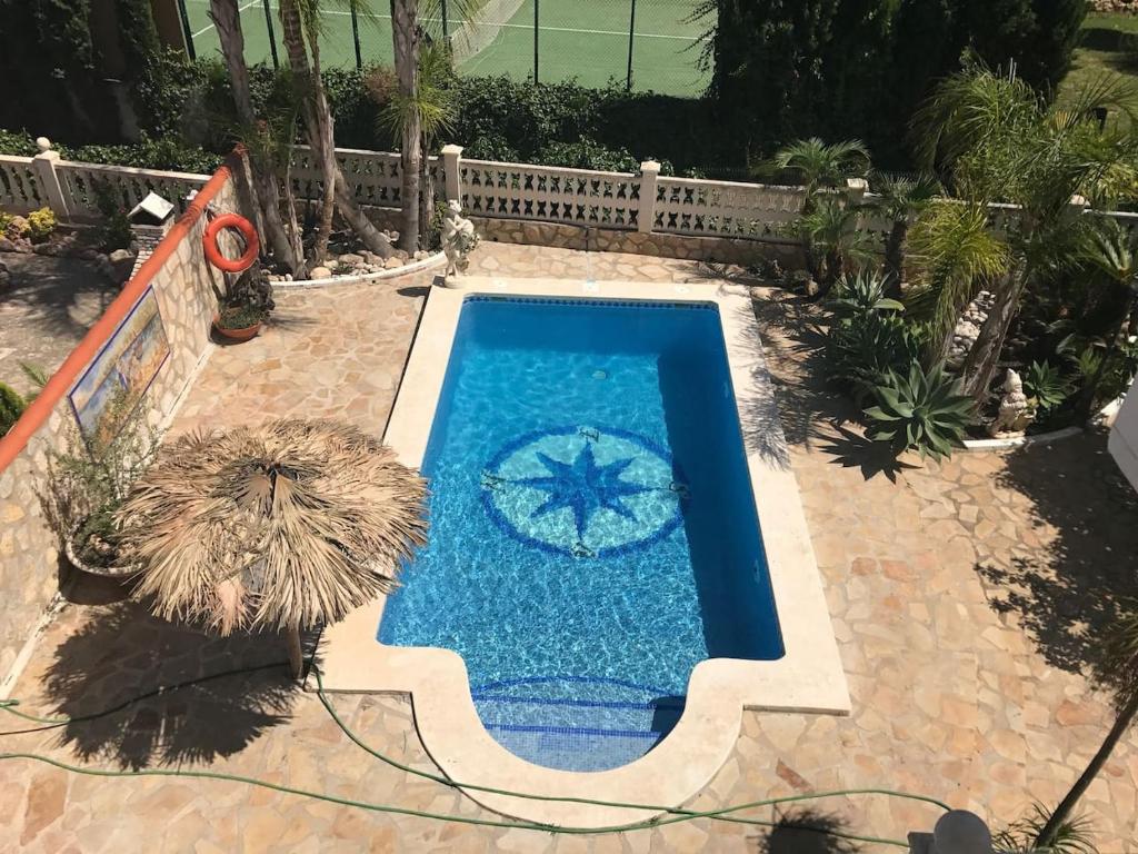 a swimming pool with an umbrella and an umbrella at Villa SOLMAR in Peniscola