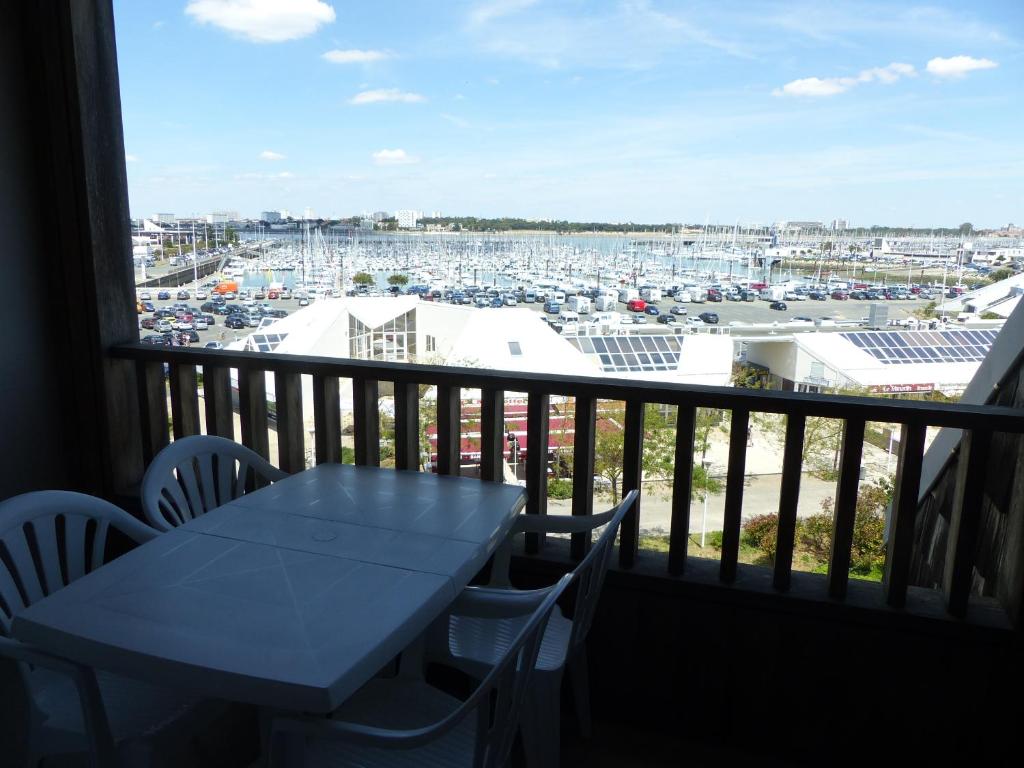 d'un balcon avec une table, des chaises et un port. dans l'établissement Plage des Minimes PONANT 6 VUE MER, à La Rochelle