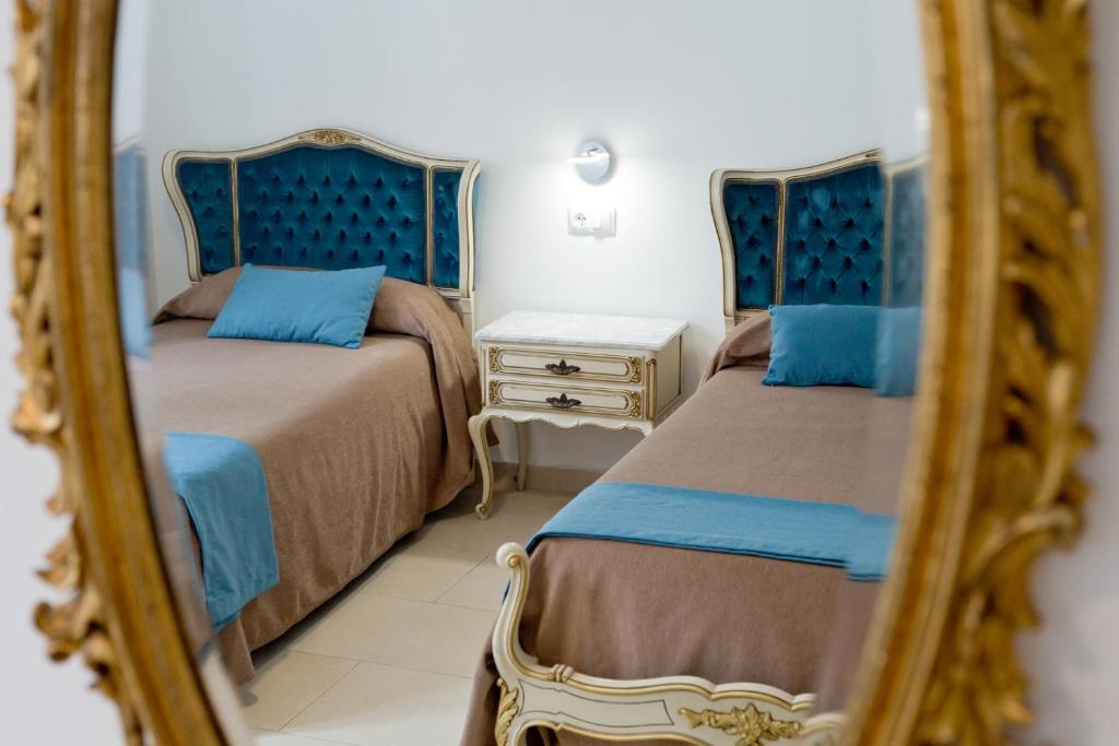 1 dormitorio con 2 camas y espejo en Hotel Maritimo, en Alicante