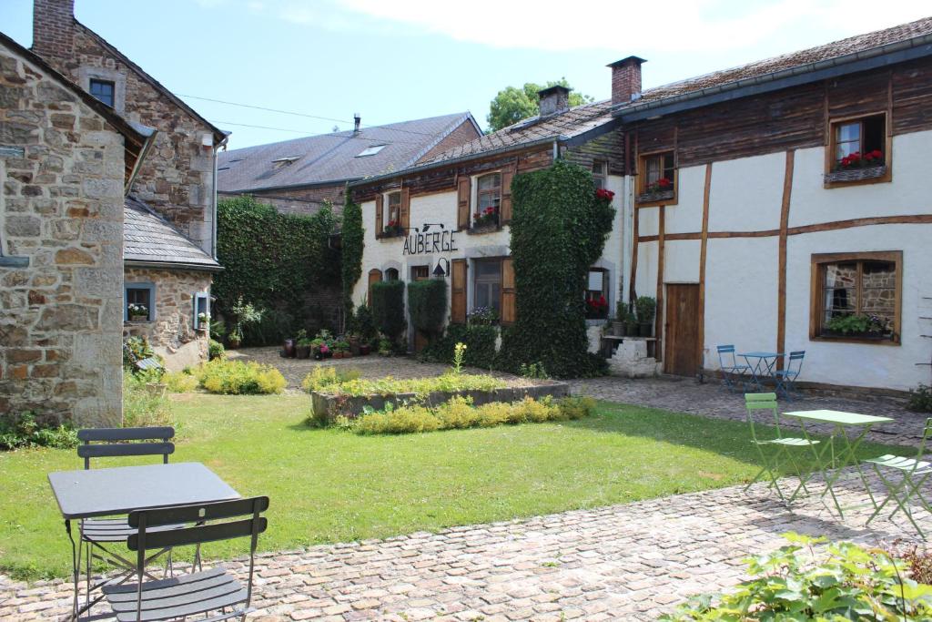 een tuin met een tafel en stoelen voor een gebouw bij Auberge du Val d'Aisne in Fanzel
