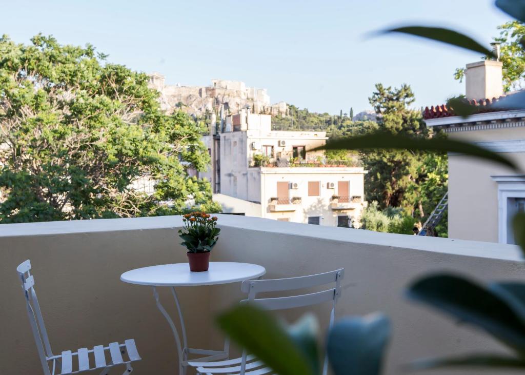 d'une petite table et de chaises sur un balcon avec vue. dans l'établissement One Three One - In the Heart of Athens, à Athènes