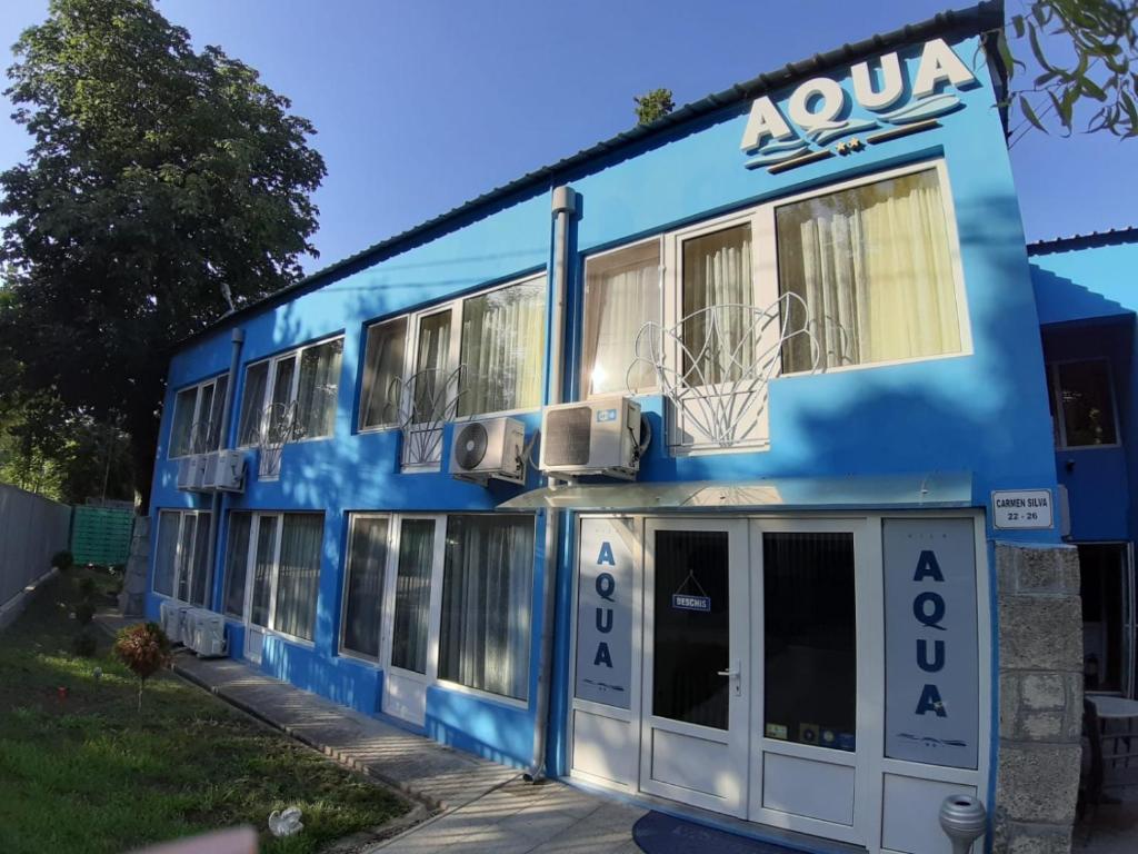 ein blaues Gebäude mit einem Basketballkorb darüber in der Unterkunft Vila Aqua in Eforie Sud