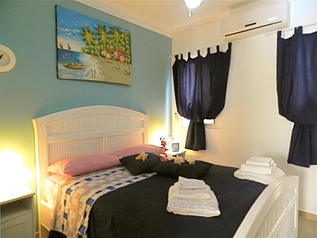 a bedroom with a bed with clothes on it at Vanilla House in Bayahibe