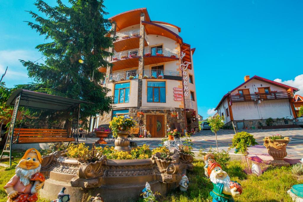 a building with a fountain in front of it at Sadyba u Halyny in Bukovel