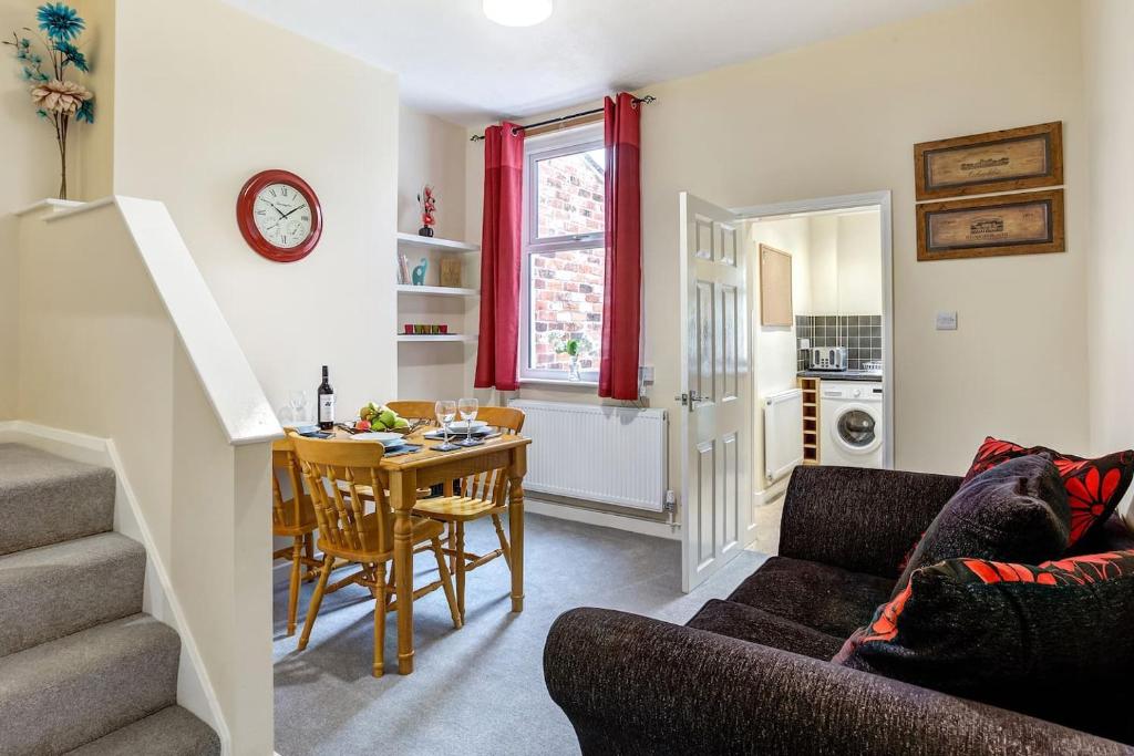 a kitchen and living room with a table and chairs at Cloud View Cottage in Congleton