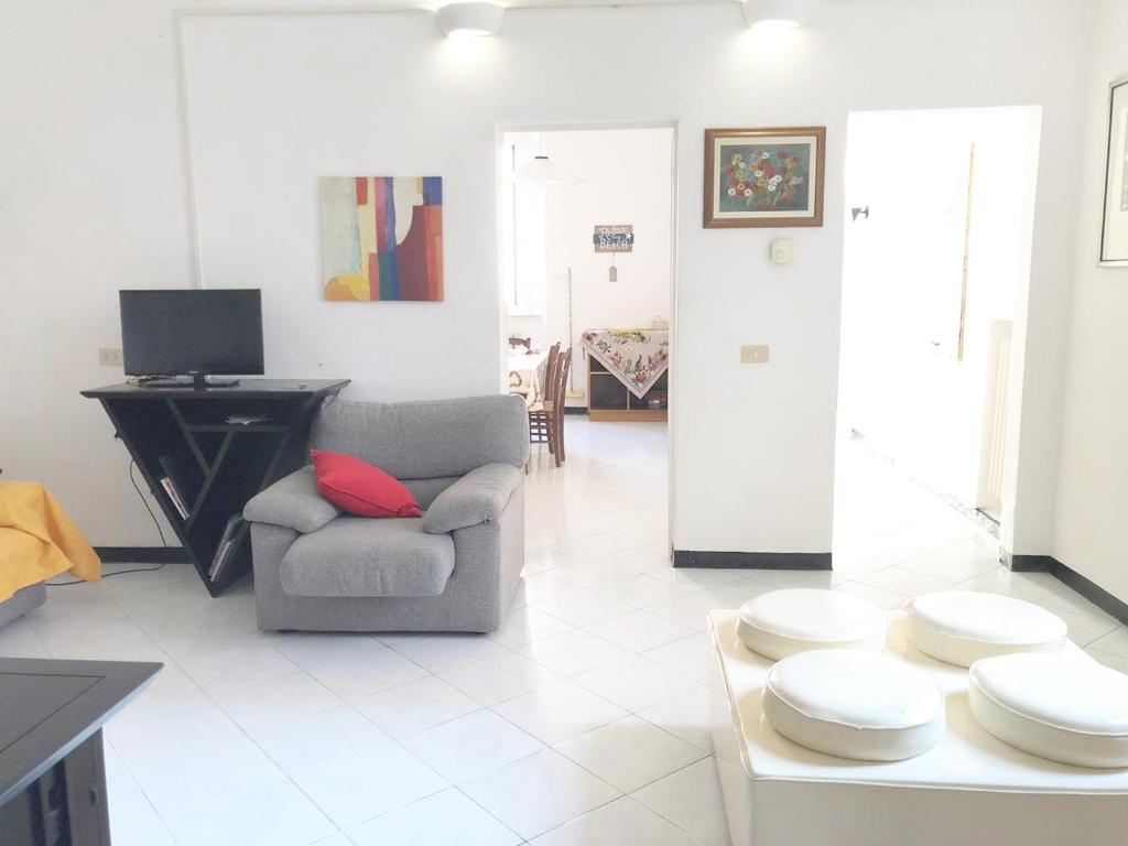 ein Wohnzimmer mit einem Sofa und einem Stuhl in der Unterkunft Casa Ada in Marina di Cecina