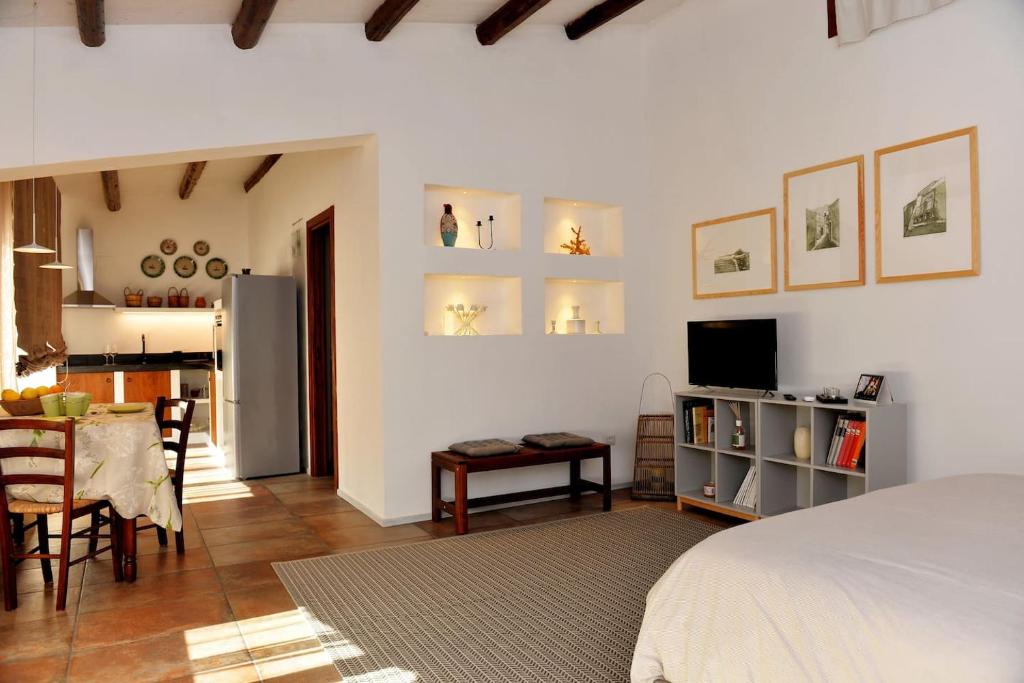 a bedroom with a bed and a table and a kitchen at Suite in Masseria in Plemmirio