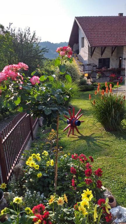 a garden with flowers in front of a house at Apartmani Mali Raj Rudnik in Rudnik