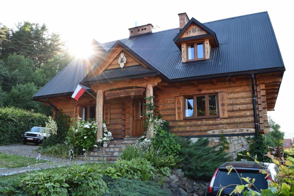 ウストシキ・ドルネにあるPrzystań Gromadzyńの黒屋根の丸太小屋