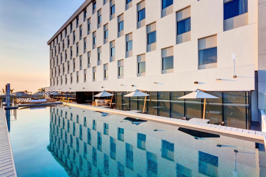 a hotel swimming pool in front of a building at Movich Buro 51 in Barranquilla