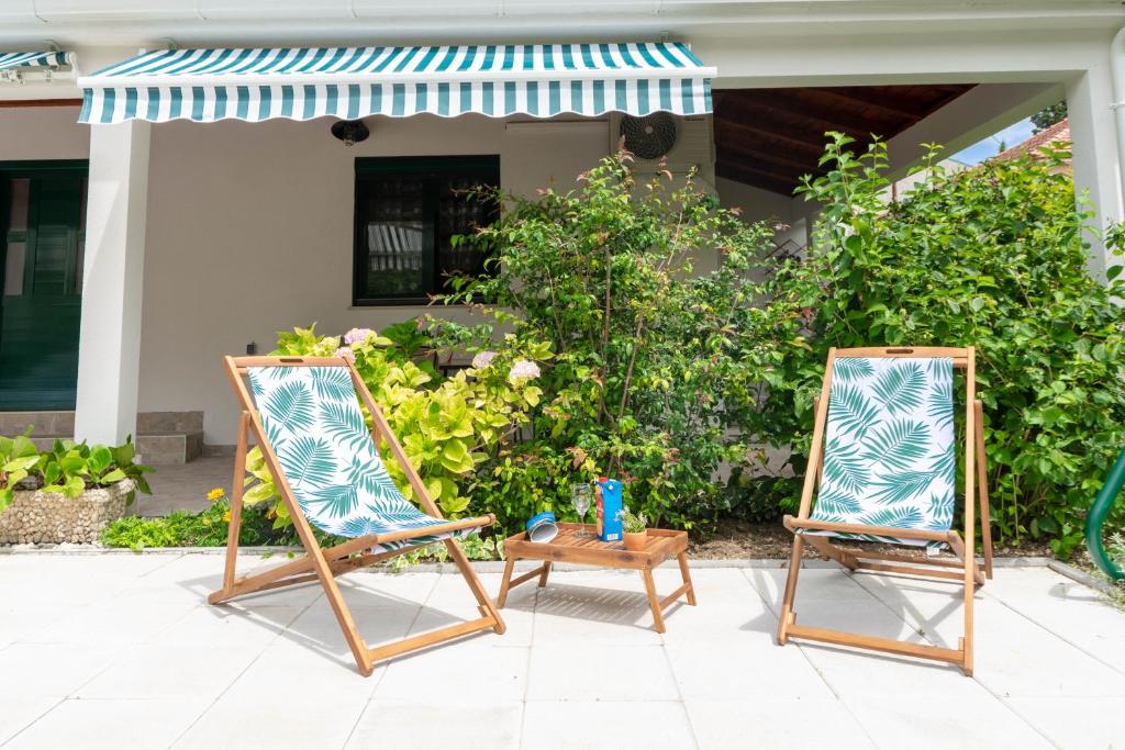 - deux chaises de plage assises sur une terrasse à côté d'une table dans l'établissement 50 meters from the beach! Apartment Flower, à Kaštela