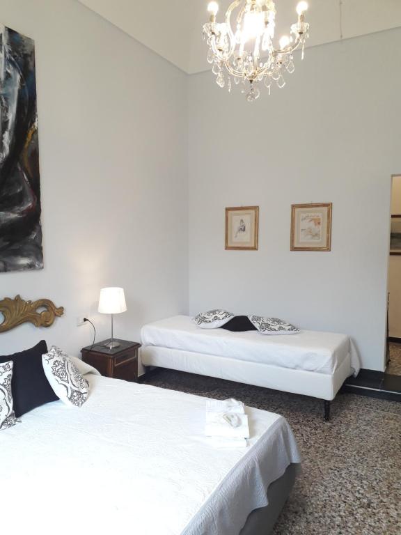 two beds in a room with a chandelier at DORA AUREA in Levanto