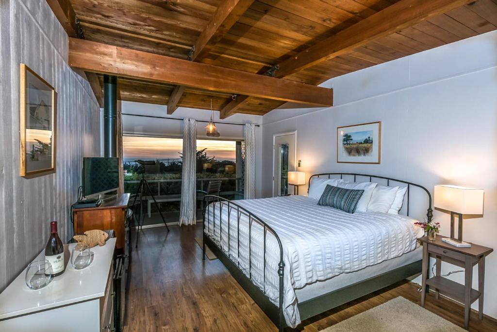 um quarto com uma cama e uma varanda em Inn at Schoolhouse Creek em Mendocino