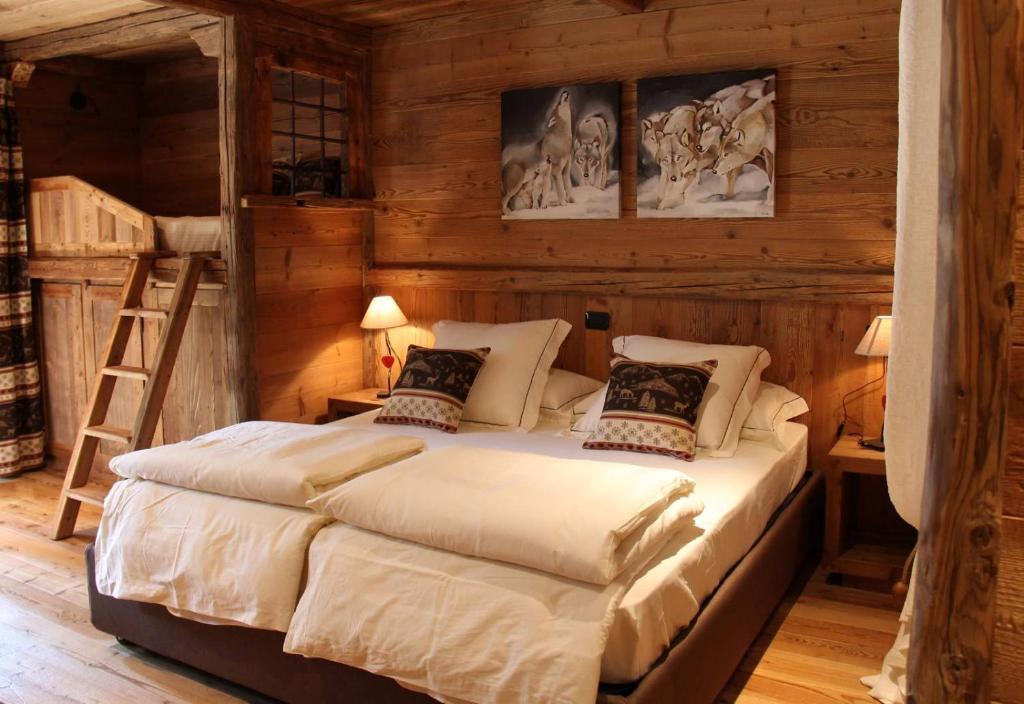 1 dormitorio con 1 cama en una habitación de madera en Les Trompeurs chez Odette, en Cogne