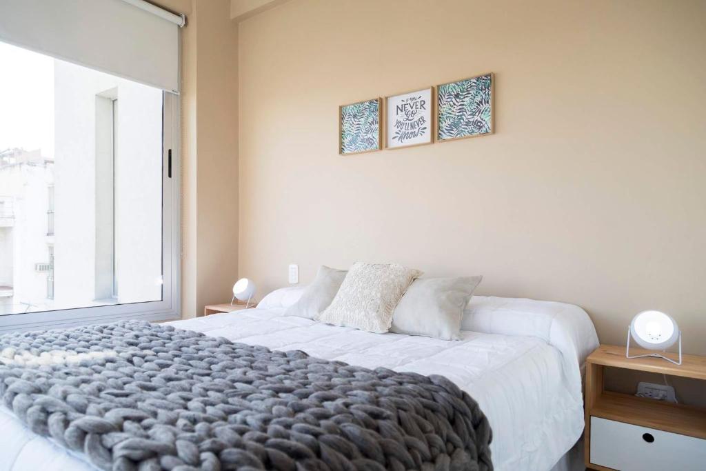 Un dormitorio con una cama grande y una ventana en DEL SOL Apartamentos Salta en Salta
