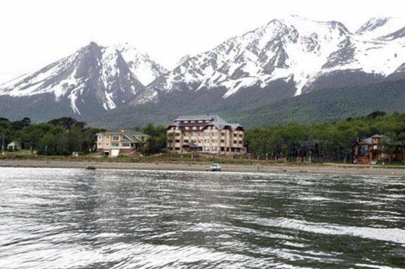 a large body of water with a mountain in the background at Costa Ushuaia in Ushuaia