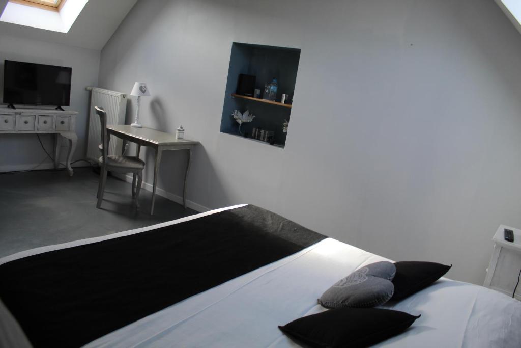 um quarto com uma cama, uma secretária e uma televisão em L'Heure Bleue gîtes et chambres d'hôtes em Givenchy-en-Gohelle