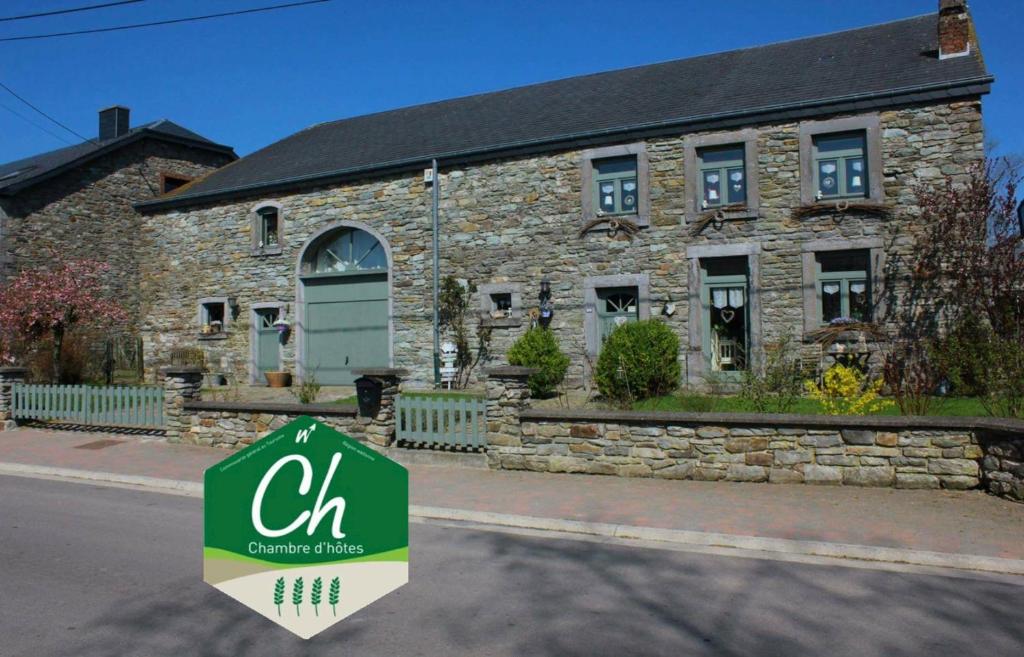 a sign in front of a stone building at A la Grange d'en Haut in Bras-Haut