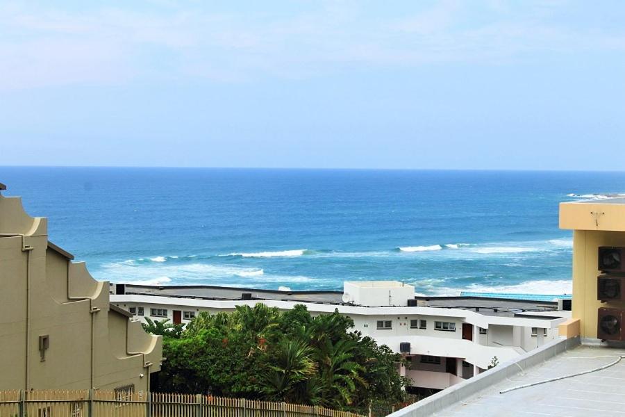 a view of the ocean from the balcony of a building at Uvongo Lucian Blue Flag Beach Apartment in Margate