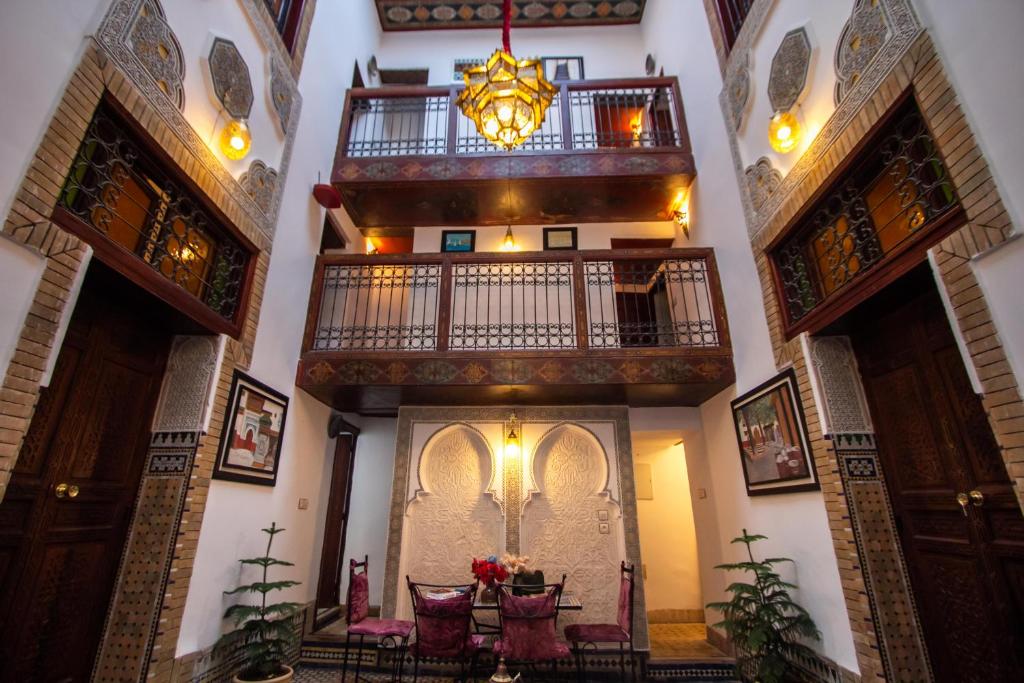 a room with a table and chairs in a building at Dar Bab Jdid in Fez