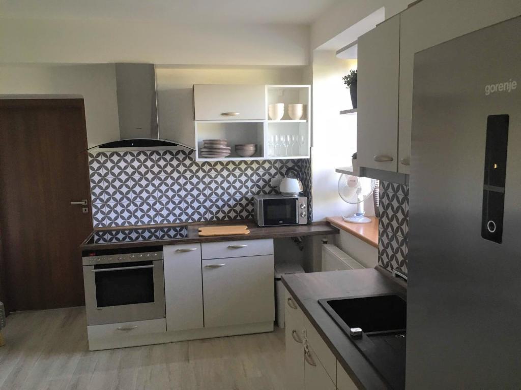 a small kitchen with white cabinets and a stove at Apartmám na náměstí II in Opočno