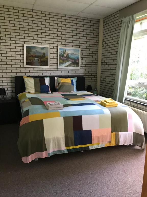 1 dormitorio con 1 cama grande con una manta colorida en Masterlik, en Driesum