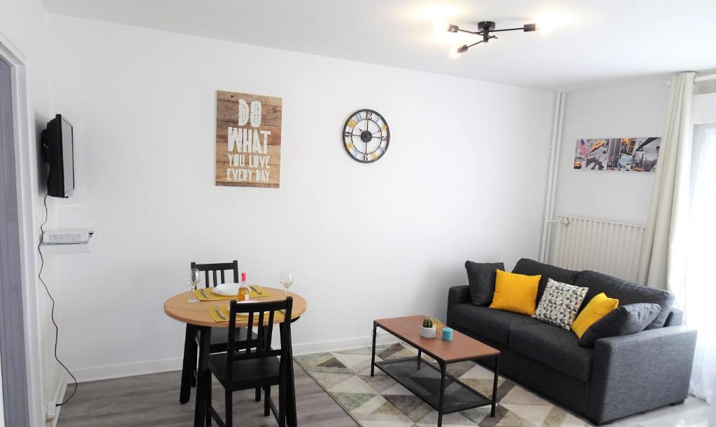 a living room with a couch and a table at Appartement Le Mans Libération in Le Mans