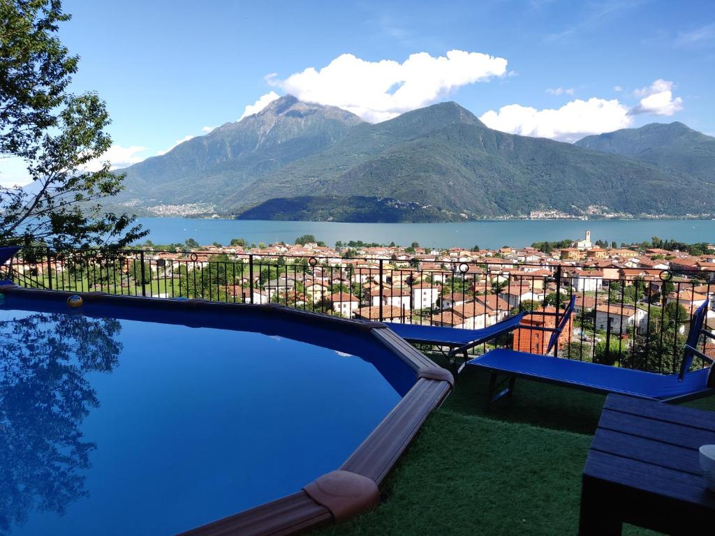 uma piscina com vista para uma cidade e montanhas em Ulivi on the Lake em Dongo