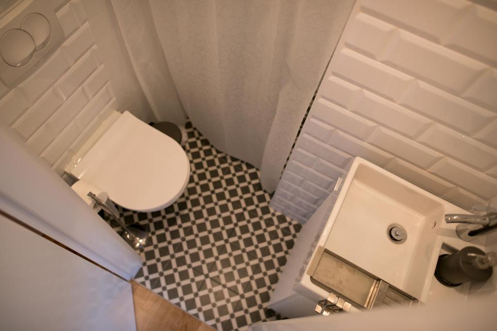 La petite salle de bains est pourvue de toilettes et d'un lavabo. dans l'établissement MAGIC GARDEN ZAGREB CENTER, à Zagreb